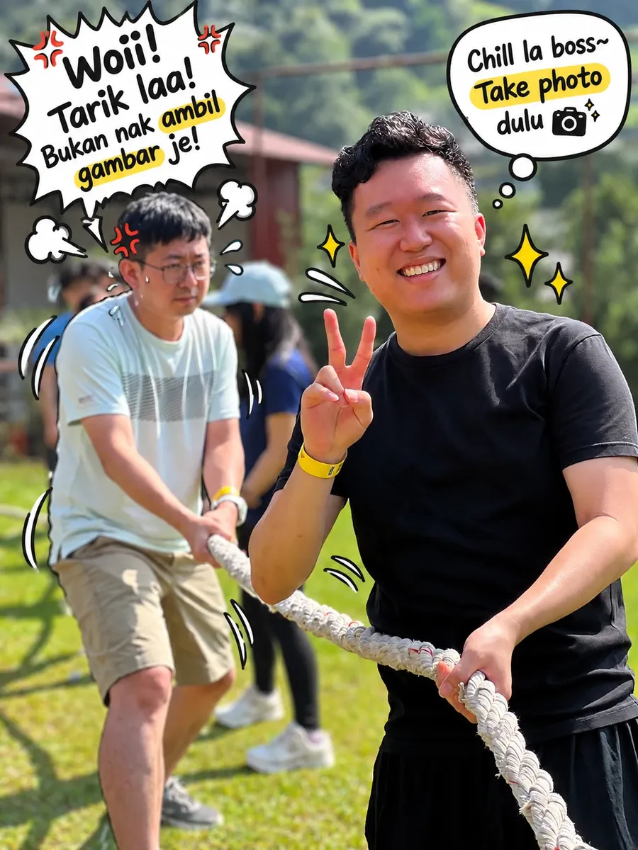 A teammate grinning and making a peace sign during tug of war while the teammate behind him pulls hard. Comic speech bubbles: "Woii! Tarik laa! Bukan nak ambil gambar je!" and "Chill la boss~ Take photo dulu"